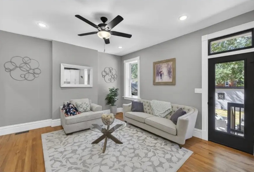 Sitting room with a glass coffee table, hardwood floors and black glazed exterior door