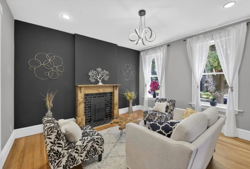 Fireplace and sitting area framed by tall windows and white trim