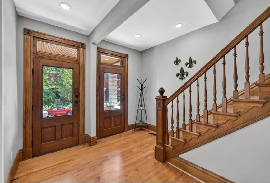 Entryway with two glazed wood doors, wood staircase and recessed ceiling lights