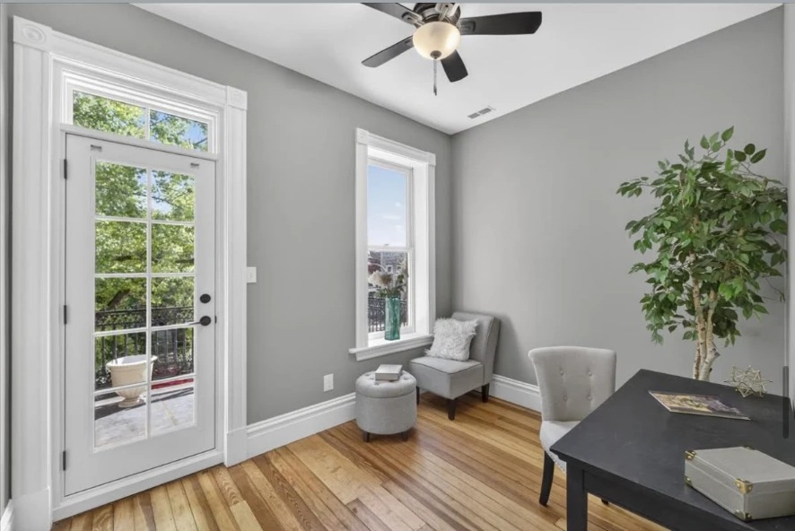 Sitting room with glazed exterior door, ceiling fan, armchairs and hardwood floor