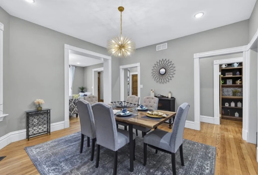 Dining room with hardwood floors, a gold pendant and built-in shelves