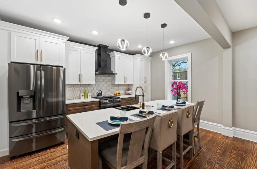 Kitchen island with upholstered bar stools, white countertops and stainless appliances