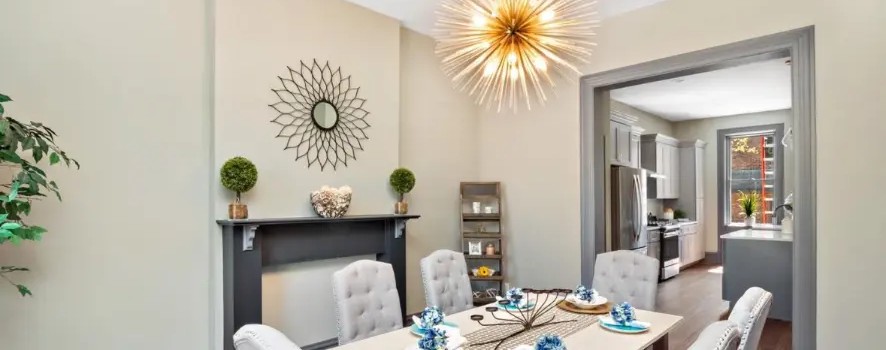 Dining room with dark mantel, starburst chandelier and view into the kitchen