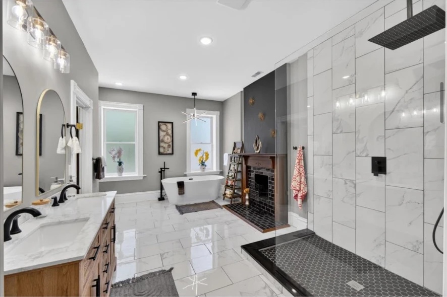 Bathroom with wood double vanity, freestanding tub, fireplace and glass-enclosed tiled shower